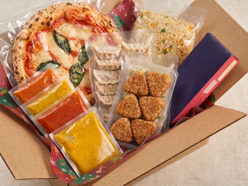 みんなの食卓ボックスのイメージ（レトルトのスープやカレー、ピザ、餃子、チャーハン、焼きおにぎり、ケーキの箱）